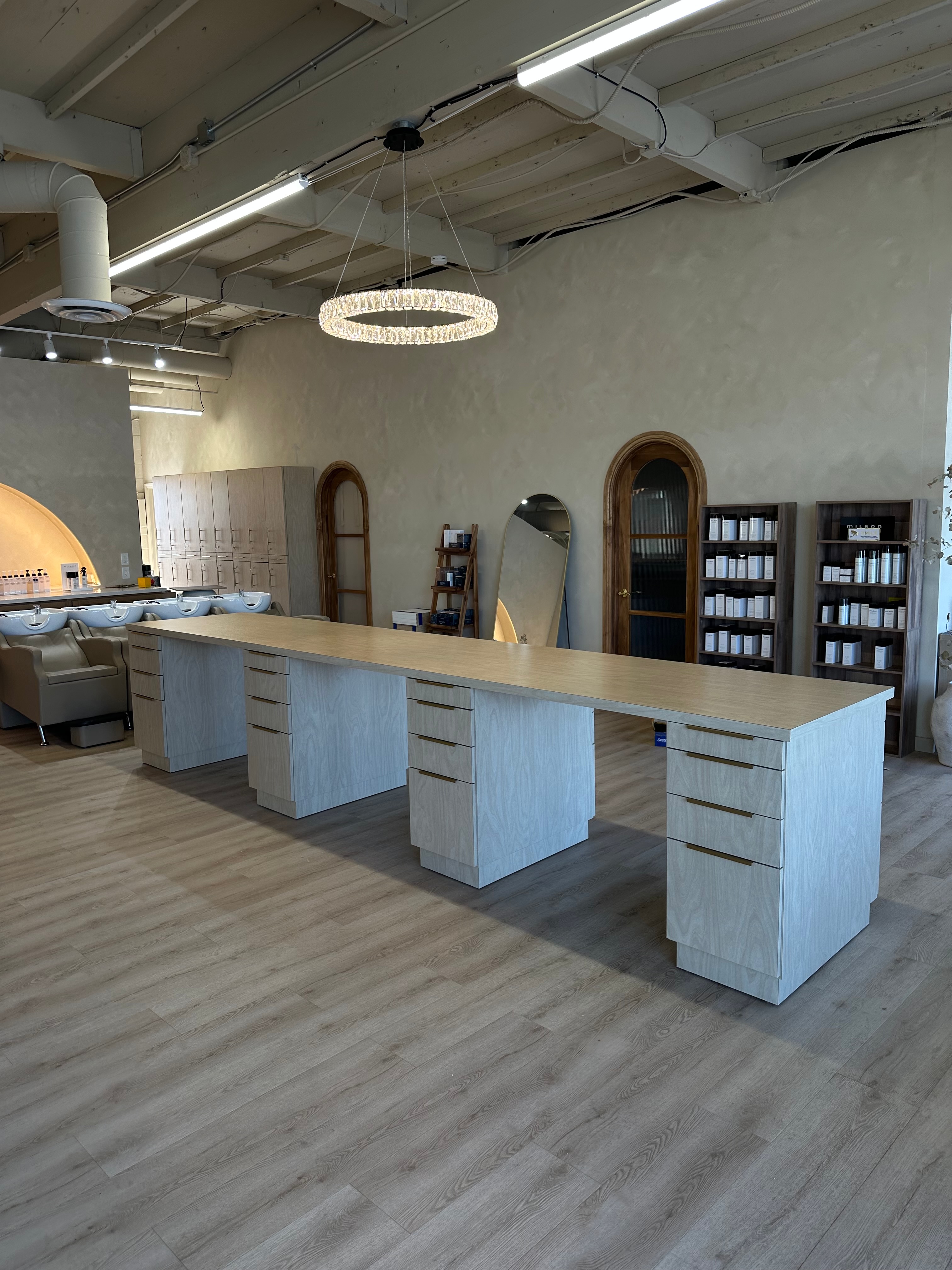 Long light-wood station bank with statement chandelier