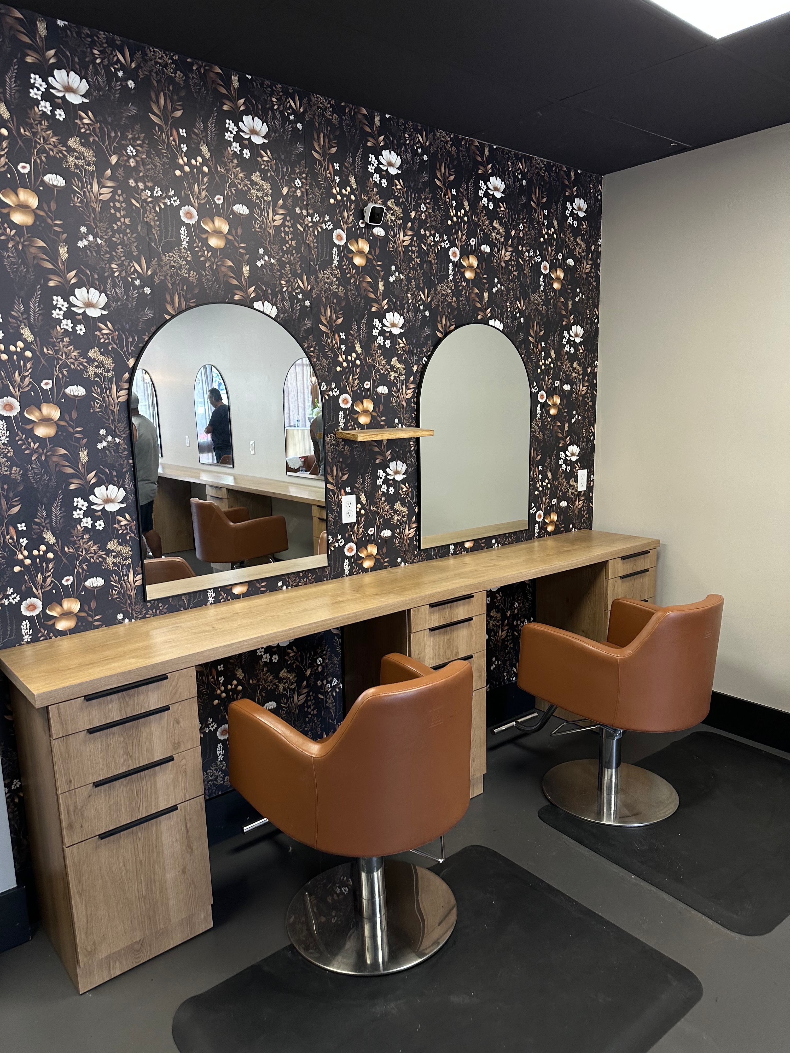 Salon styling stations with arched mirrors and wood cabinetry